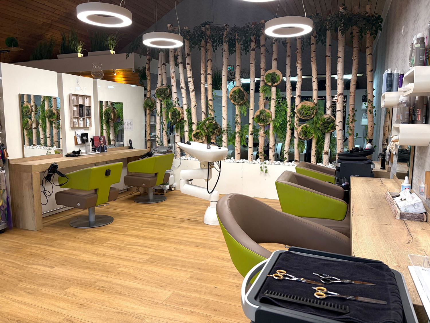 Salonbereich mit Birkenwand, Waschplatz und bereitliegendem Scherenset